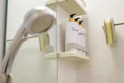 a bathroom with a mirror and two soap dispensers at Sakura Court Ebisu 405 in Tokyo