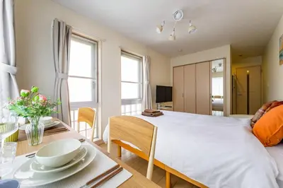 a bedroom with a large bed and a table with chairs at Sakura Court Ebisu 405 in Tokyo