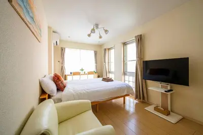 a bedroom with a bed and a tv and a couch at Sakura Court Ebisu 405 in Tokyo