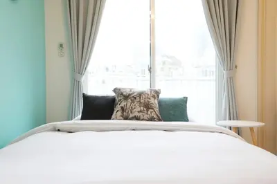 a bedroom with a white bed and a window at Sakura Court Ebisu 501 in Tokyo