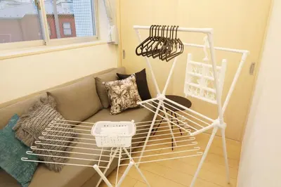 a living room with a couch and a metal rack at Sakura Court Ebisu 501 in Tokyo