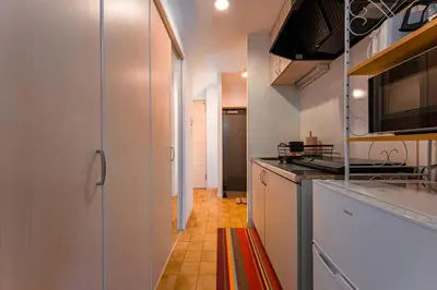 a kitchen with white cabinets and a stove top oven at Sakura Court Ebisu 502 in Tokyo