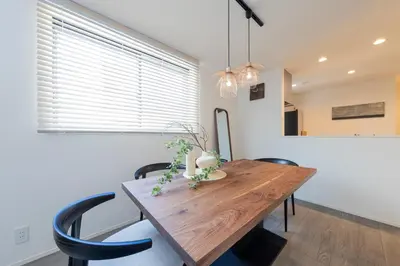 a dining room with a wooden table and black chairs at Jack of clubs inn in Tokyo