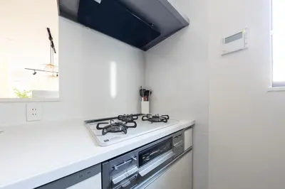 a kitchen with a stove top oven next to a window at Jack of clubs inn in Tokyo