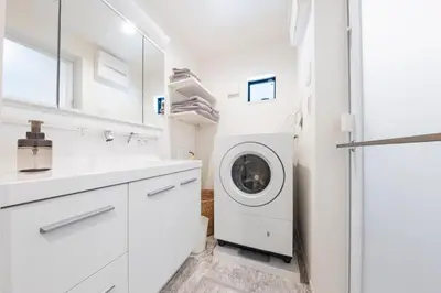 a white laundry room with a washer and dryer at Jack of clubs inn in Tokyo