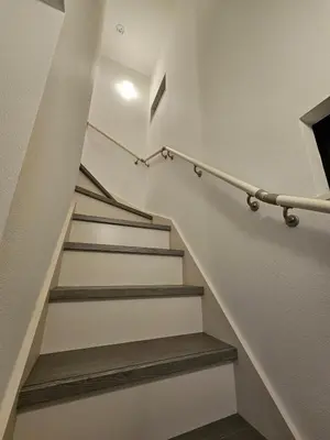 a staircase in a home with white walls and wooden stairs at Jack of clubs inn in Tokyo