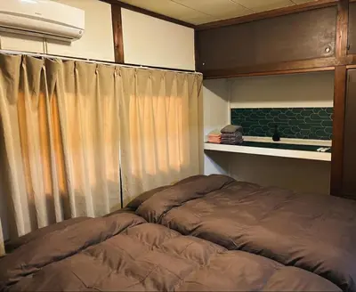 a bedroom with a bed in front of a window at Komone House in Tokyo