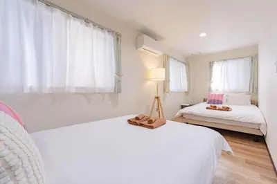 a bedroom with two beds and a pair of shoes on top of them at \u4e80\u67095\u4e01\u76ee301 in Tokyo