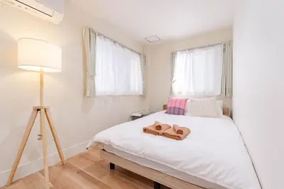 a bedroom with a bed with two slippers on it at \u4e80\u67095\u4e01\u76ee301 in Tokyo