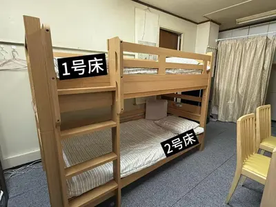 a room with two bunk beds with writing on them at \u70df\u96e8\u8f69105 in Tokyo