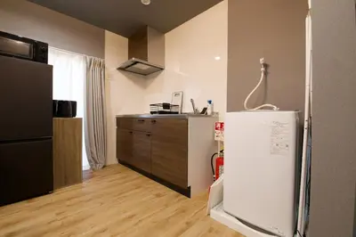 a kitchen with a refrigerator and a wooden floor at Higashi Koiwa 6 Chome House 1F in Tokyo