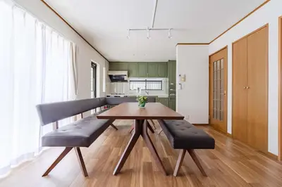 a dining room with a wooden table and black chairs at BF Stay Shinjukugyoen in Tokyo