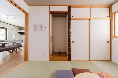 a living room with white walls and a sliding door at BF Stay Shinjukugyoen in Tokyo
