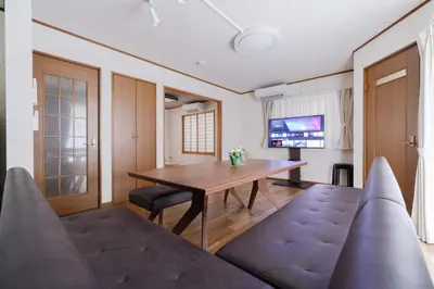 a dining room with a wooden table and chairs at BF Stay Shinjukugyoen in Tokyo