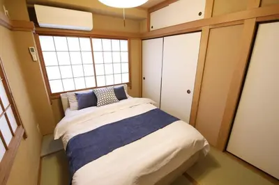 a bedroom with a bed in a room with two windows at \u30bd\u30ec\u30a4\u30e6\u30cf\u30a6\u30b9\u897f\u845b\u897f in Tokyo