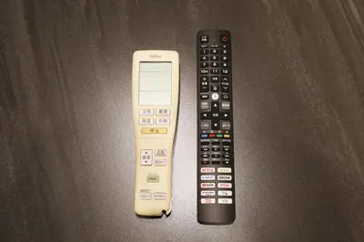 two remote controls sitting next to each other on a table at \u30bd\u30ec\u30a4\u30e6\u30cf\u30a6\u30b9\u897f\u845b\u897f in Tokyo