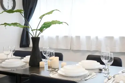 a dining room table with white plates and a vase with a plant at \u30bd\u30ec\u30a4\u30e6\u30cf\u30a6\u30b9\u897f\u845b\u897f in Tokyo