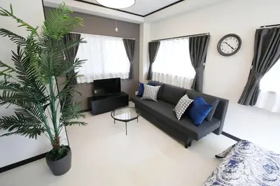a living room with a couch and a palm tree at \u30bd\u30ec\u30a4\u30e6\u30cf\u30a6\u30b9\u897f\u845b\u897f in Tokyo