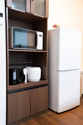 a kitchen with a microwave and a refrigerator at Sunbright Asakusa 201 in Tokyo