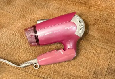 a pink hair dryer sitting on a wooden floor at -Centray Okachimachi 102- 1 minute to Akihabara Station and Ueno Station without transfers! in Tokyo