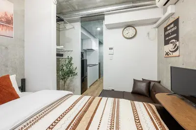 a bedroom with a bed and a clock on the wall at -Centray Okachimachi 102- 1 minute to Akihabara Station and Ueno Station without transfers! in Tokyo