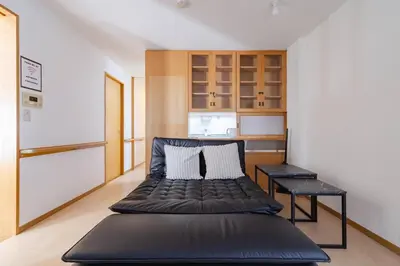 a large black bed in a room with a kitchen at \u4e80\u67095\u4e01\u76ee201 in Tokyo