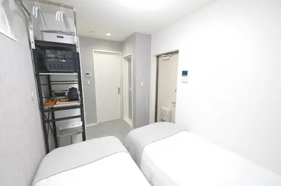 a small room with two beds and a kitchen at 11AM out, Asakusa Base, 3F Skytree-View Rooms, Projector Mini Theater in Tokyo