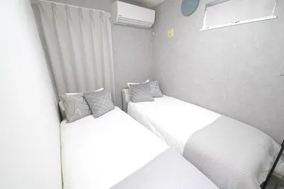 two beds in a small room with white sheets at 11AM out, Asakusa Base, 3F Skytree-View Rooms, Projector Mini Theater in Tokyo