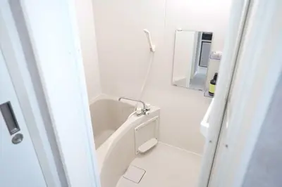 a white bathroom with a tub and a mirror at 11AM out, Asakusa Base, 3F Skytree-View Rooms, Projector Mini Theater in Tokyo