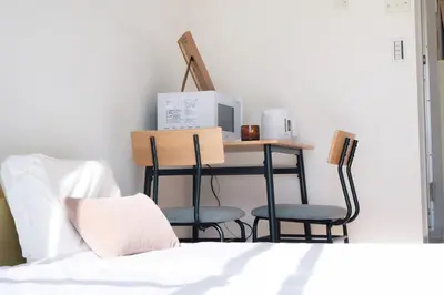 a bedroom with a desk with two chairs and a bed at Ikebukuro 303 - Twin Room in Tokyo