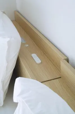 a bed with a wooden night stand next to a bed at Ikebukuro 303 - Twin Room in Tokyo