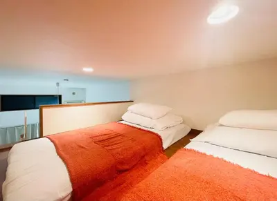 a bedroom with two beds and an orange blanket at Alo BnB 15 - Near TABATA, IKEBUKURO, SHINJUKU, UENO in Tokyo