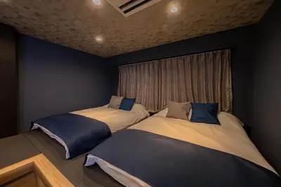 two beds in a room with a window at ZENBASE Ryogoku in Tokyo