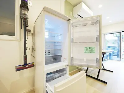 an empty refrigerator with its door open in a kitchen at IGETA HOUSE Shibuya in Tokyo