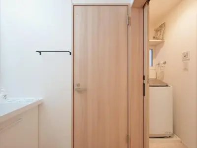 a sliding door in a bathroom with a refrigerator at IGETA HOUSE Shibuya in Tokyo