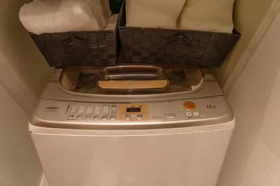 a basket sitting on top of a washing machine at \u6771\u4eac\u4e0a\u91ce\u6b65\u884c3\u5206\u72ec\u680b\u522b\u5885 in Tokyo