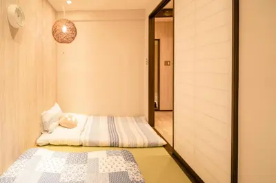 a small bedroom with a bed and a mirror at \u6771\u4eac\u4e0a\u91ce\u6b65\u884c3\u5206\u72ec\u680b\u522b\u5885 in Tokyo