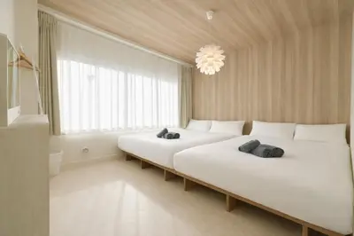 two beds in a white room with a large window at \u65b0\u5bbf5\u5206\u5e83\u3005\u7a7a\u9593 in Tokyo