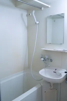 a bathroom with a sink and a mirror and a bath tub at Ikebukuro 311 - Twin Room in Tokyo