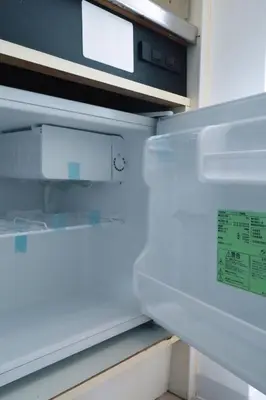 an empty refrigerator with its door open with a sticker on it at Ikebukuro 311 - Twin Room in Tokyo