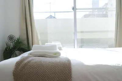 a bed with two towels on it with a window at Ikebukuro 311 - Twin Room in Tokyo