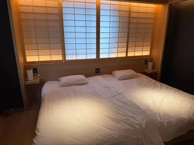 a bedroom with a large white bed with two pillows at Komorebi Rill Hotel HANA in Tokyo