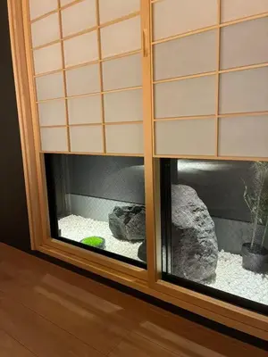a window with a rock and a plant in it at Komorebi Rill Hotel HANA in Tokyo