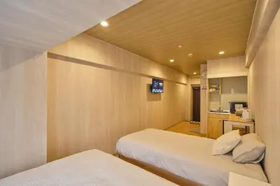 a small room with two beds and a kitchen at \u65b0\u5bbf\u5e02\u4e2d\u5fc3\u7d27\u90bb\u6b4c\u821e\u4f0e\u753a\u65b0\u5bbf\u30b4\u30fc\u30eb\u30c7\u30f3\u885713 in Tokyo