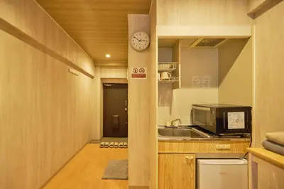 a kitchen with a sink and a clock on a pole at \u65b0\u5bbf\u5e02\u4e2d\u5fc3\u7d27\u90bb\u6b4c\u821e\u4f0e\u753a\u65b0\u5bbf\u30b4\u30fc\u30eb\u30c7\u30f3\u885713 in Tokyo