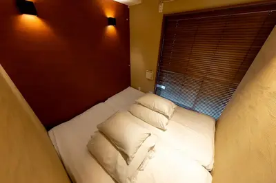 a small bed in a room with a window at \u65c5\u9928\u87a2 in Tokyo