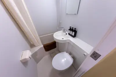 a white bathroom with a toilet and a sink at \u65c5\u9928\u87a2 in Tokyo