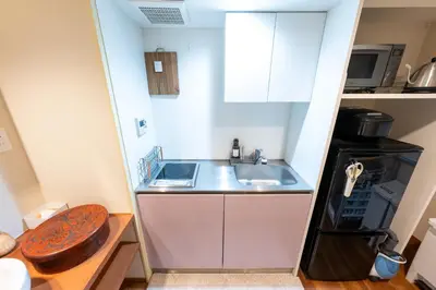 a small kitchen with a sink and a refrigerator at \u65c5\u9928\u87a2 in Tokyo