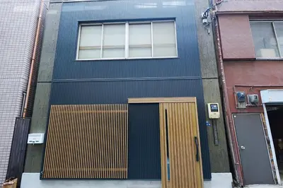 a blue building with a door and a window at HOSTEL EstLiLas KANDA \u30a2\u30cd\u30c3\u30af\u30b9 in Tokyo