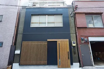 a black building with a door and a window at HOSTEL EstLiLas KANDA \u30a2\u30cd\u30c3\u30af\u30b9 in Tokyo